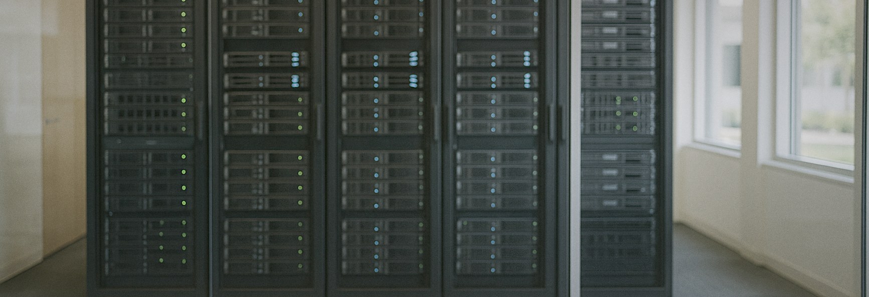 rows of enterprise servers seen through a glass wall in a bright Menlo Park office, with a smartphone resting on a table