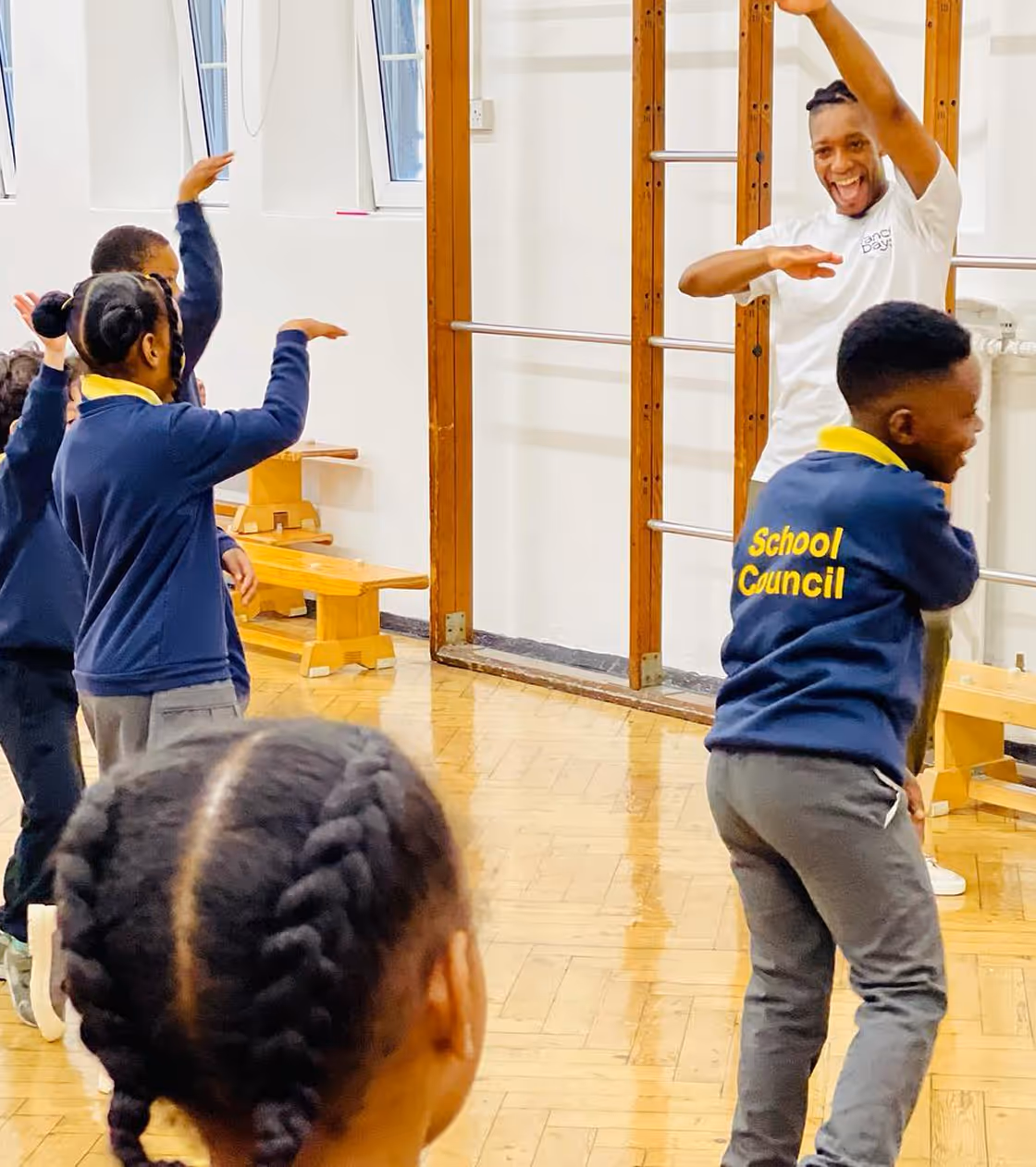 Children dancing together during a school workshop session, showing teamwork and enthusiasm for movement.

