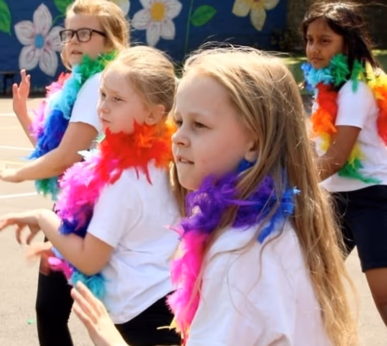 Primary school students performing a group dance routine during an interactive workshop session.