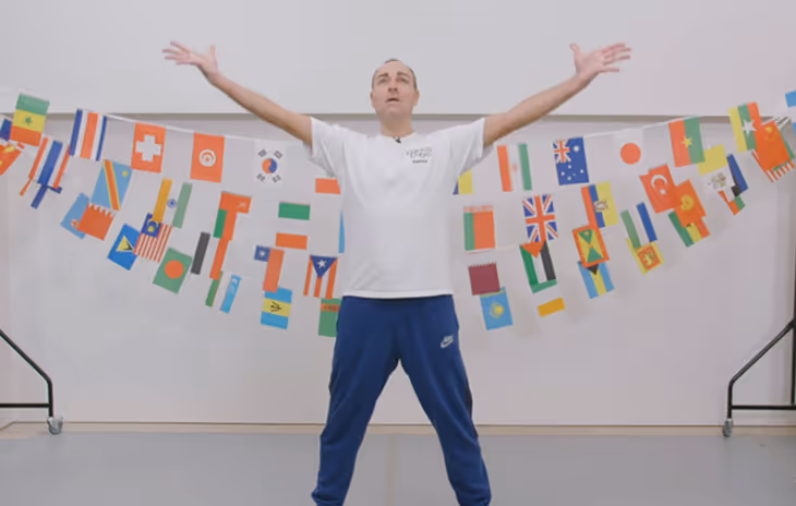 Instructor leading a dynamic warm-up session before a school dance workshop, helping students prepare with light stretches and movement drills.

