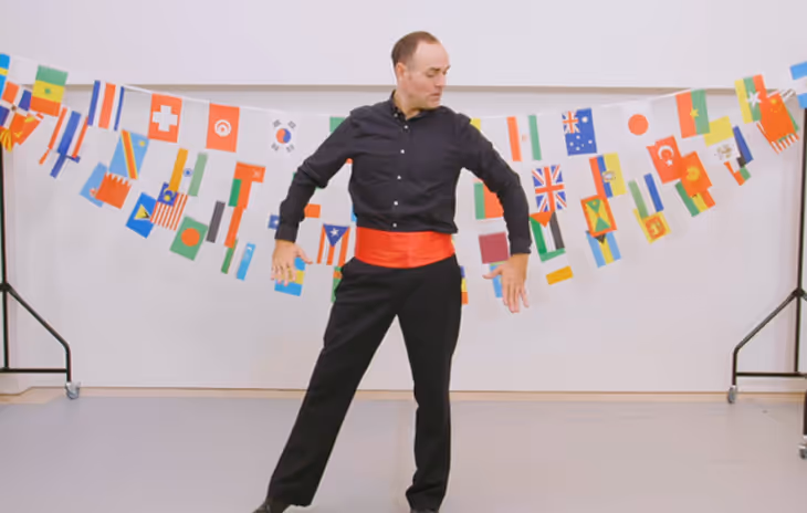 Instructor performing Flamenco dance in a workshop session, emphasizing rhythmic footwork and expressive arm movements for students.


