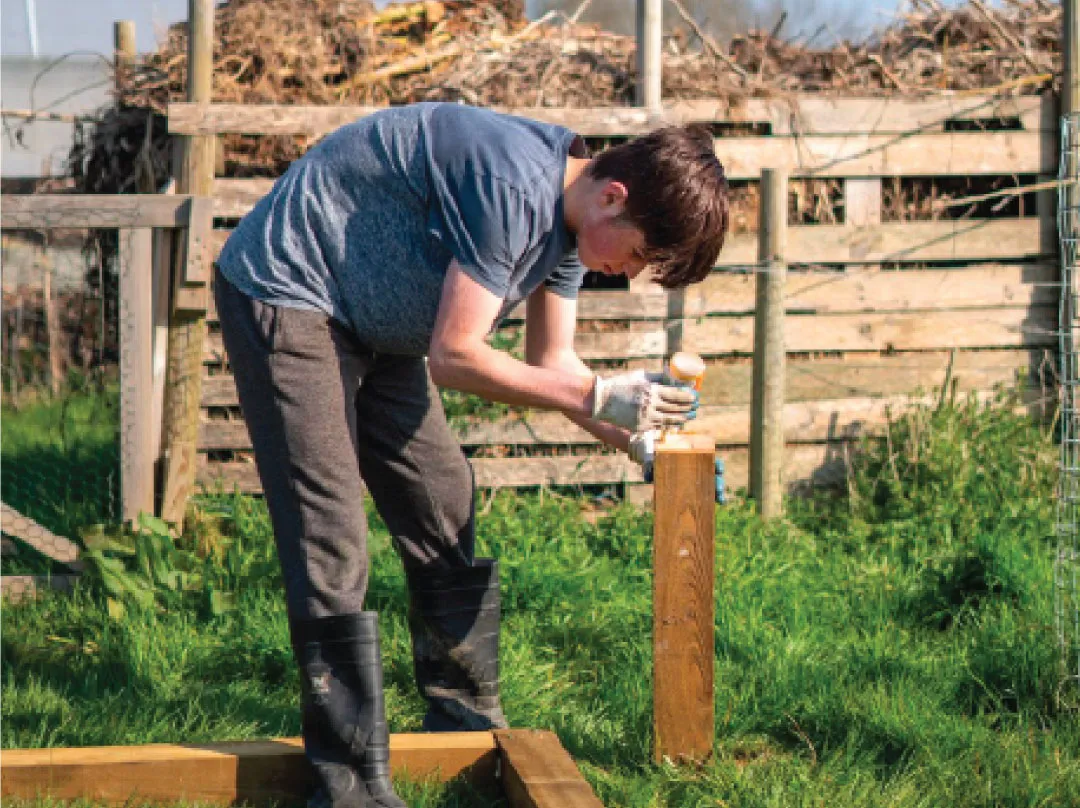 Bridge School Malvern - Small holdings outdoor space - student doing some DIY