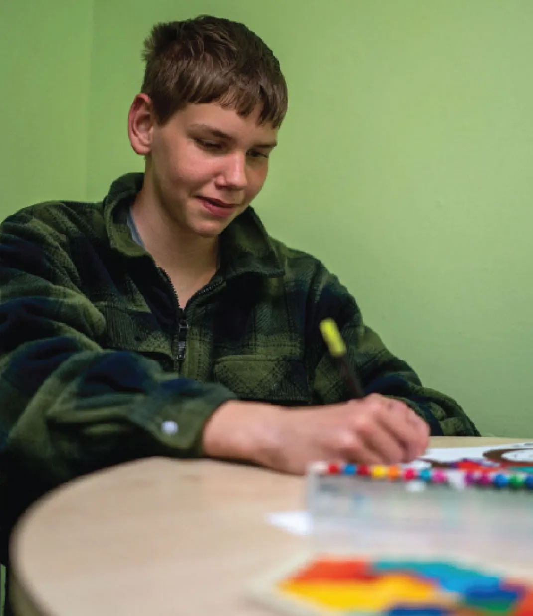 Bridge School Malvern - Pupil colouring in at table. 