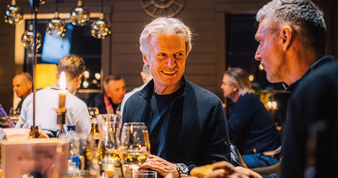 Zwei Mitglieder des ESC European Speed Club im Gespräch bei einem geselligen Abendessen während eines Events.

