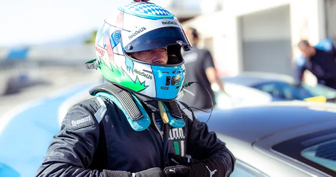 Ein voll ausgerüsteter Rennfahrer des ESC European Speed Club mit Helm und HANS-System in der Boxengasse.


