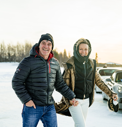 Zwei glückliche Teilnehmer des ESC European Speed Club halten Händchen und lachen beim Icedriving-Event in Schweden.

