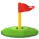 Red flag on green golf hole with tee and golf ball on grass.
