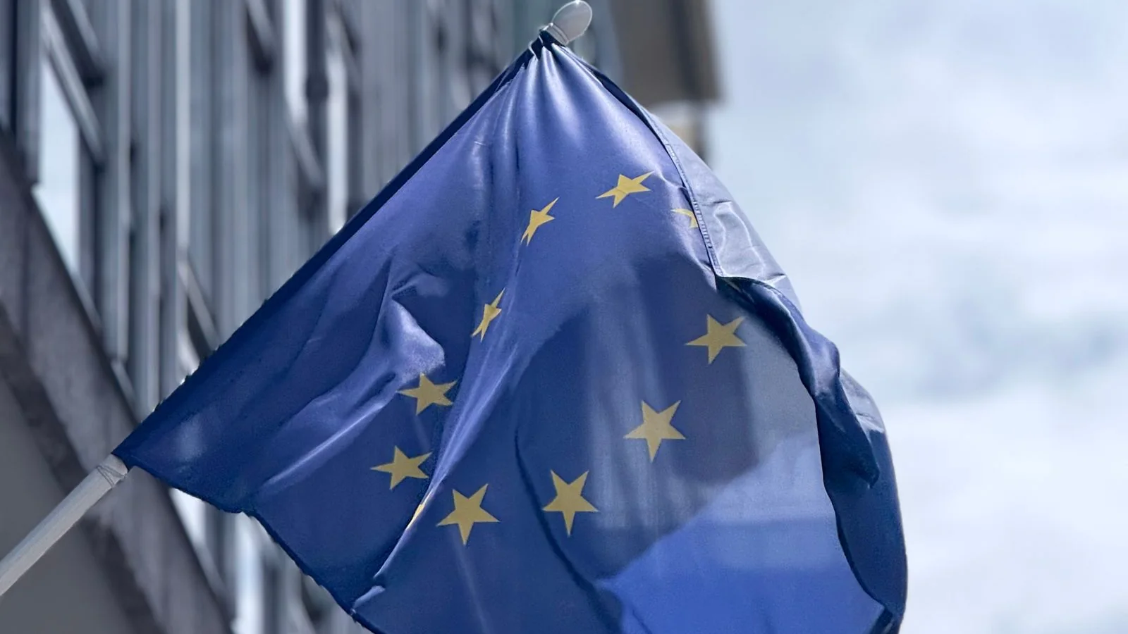 EU-Flagge weht vor einem Bürogebäude