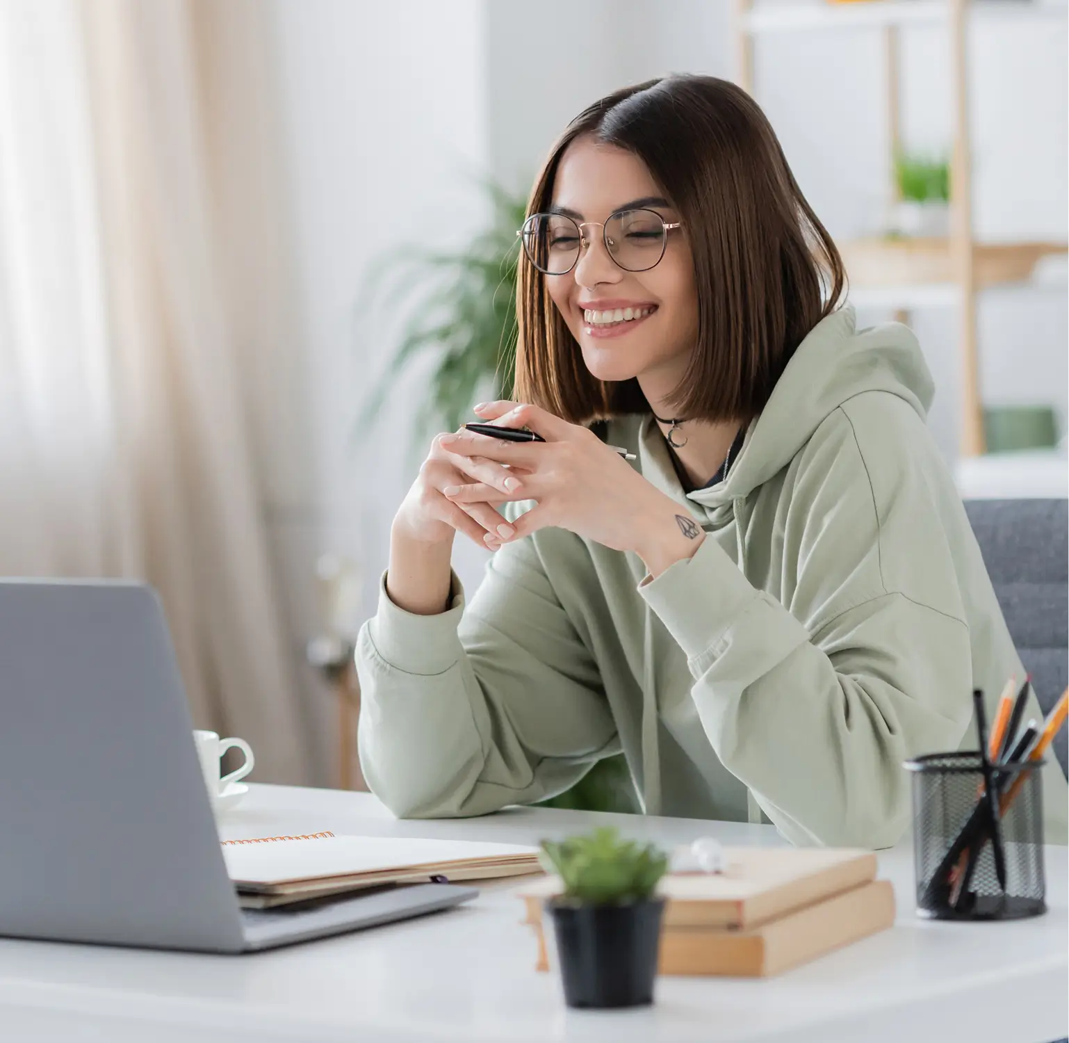 Smiling professional at desk, representing the diverse talent pool available through Somewhere’s direct hire service.