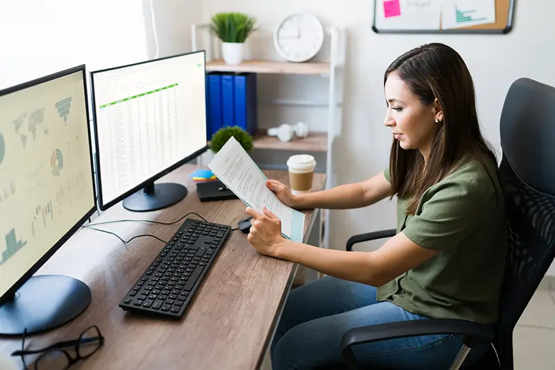 Professional data analyst reviewing reports with dual monitors showcasing world-class analytics talent for recruitment