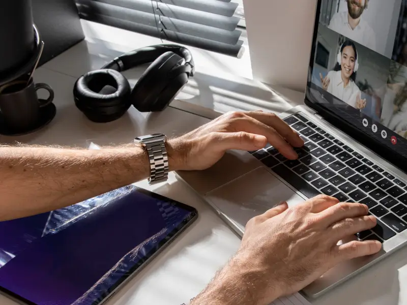 Business leader conducting remote interview on laptop demonstrating international sales recruitment and hiring capabilities