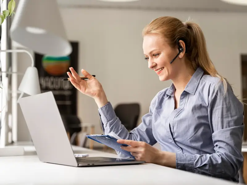 Professional woman with headset conducting B2B sales calls with documents demonstrating expert remote sales service capabilities