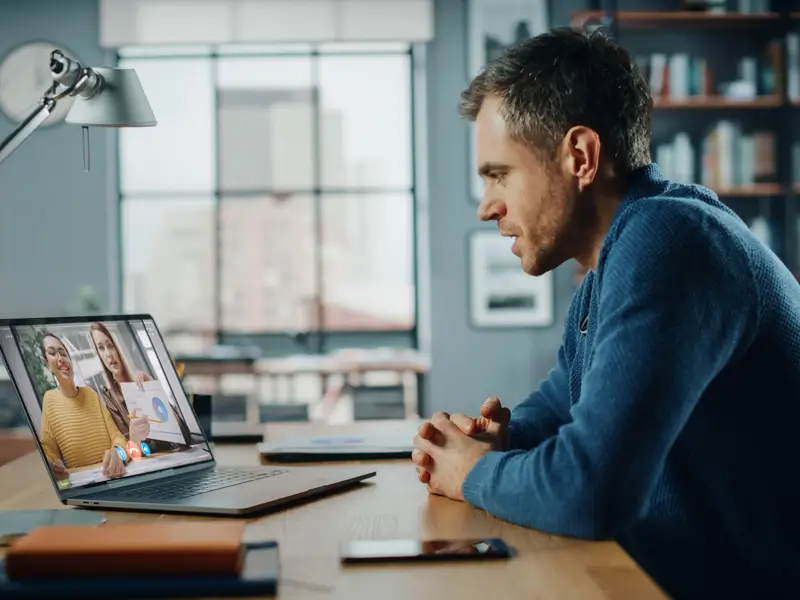 Remote worker connecting with diverse global team members via video conference for business development strategies