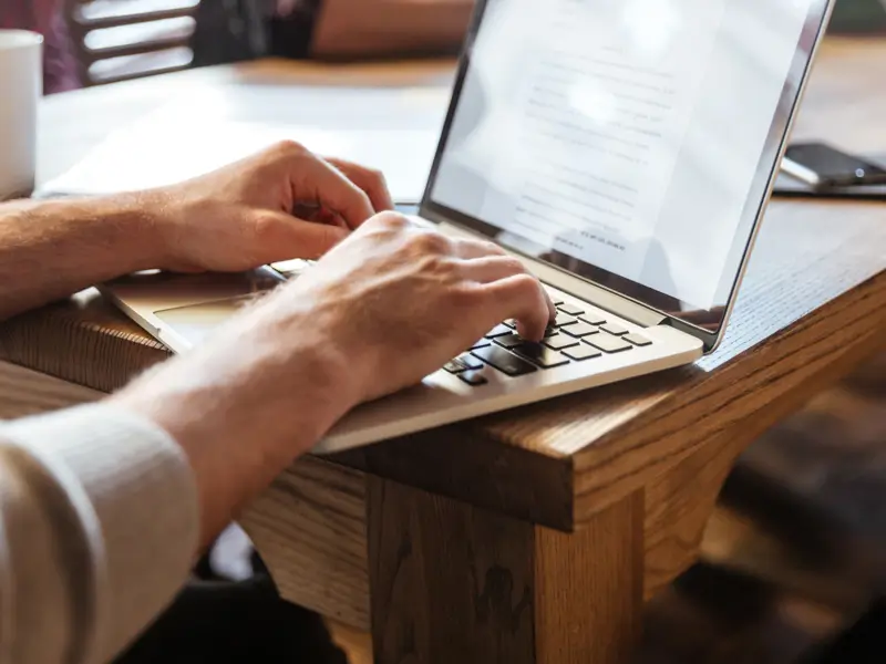 Business professional working on laptop managing remote team operations and global talent coordination effectively