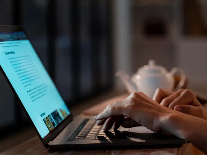 Remote worker typing on laptop utilizing AI tools for modern hiring and talent acquisition workflows