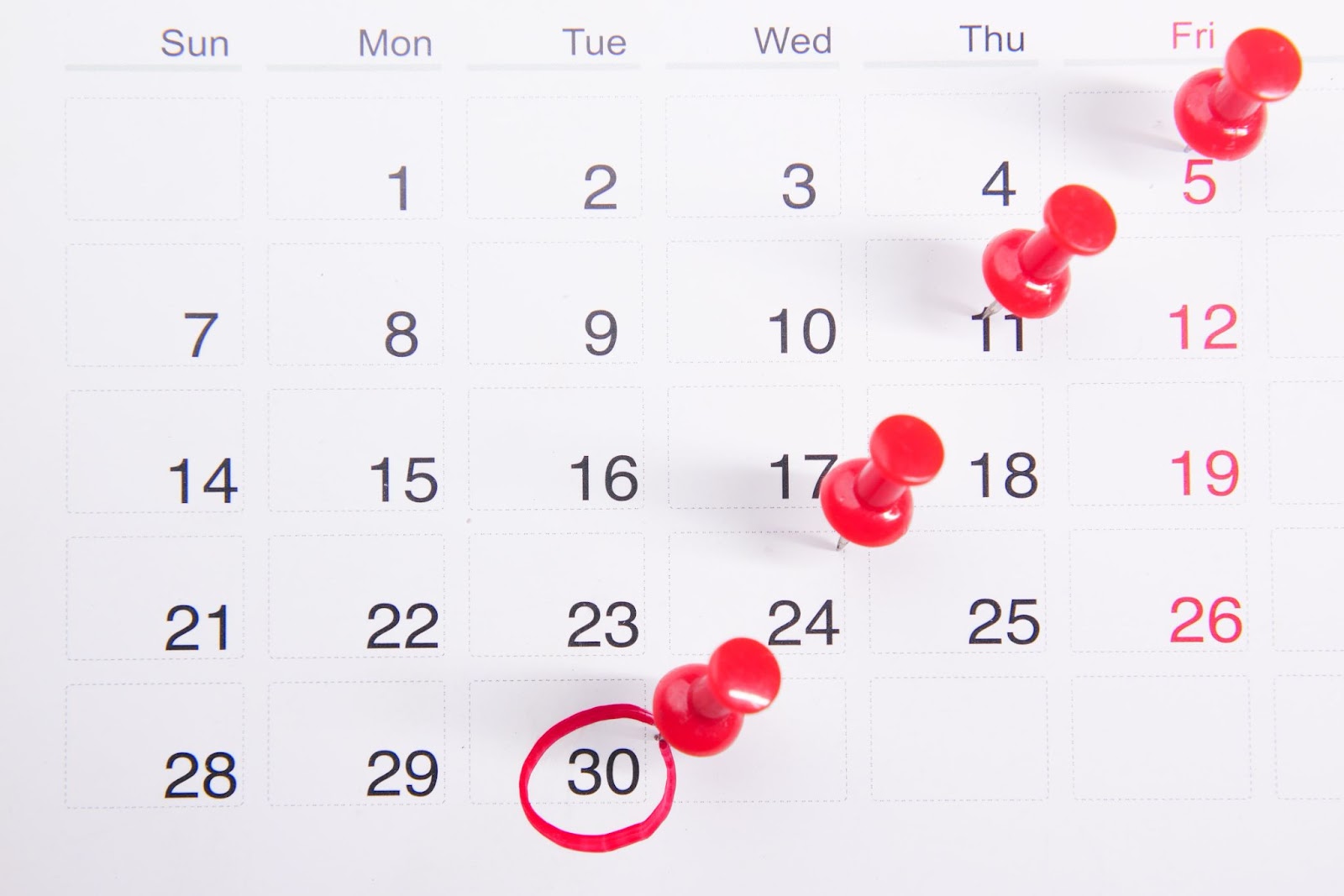 A calendar with red pins on important deadlines