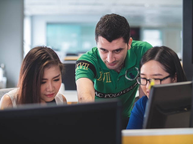 Three people looking at a computer screen