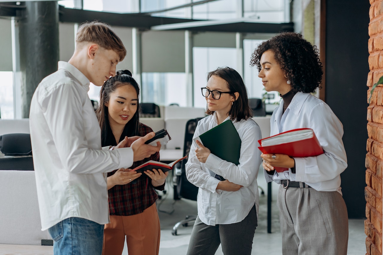 A group of young people standing in an office making plans