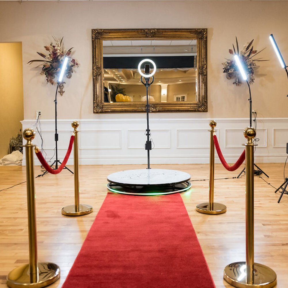 360 photo booth platform with a red carpet and gold stanchions