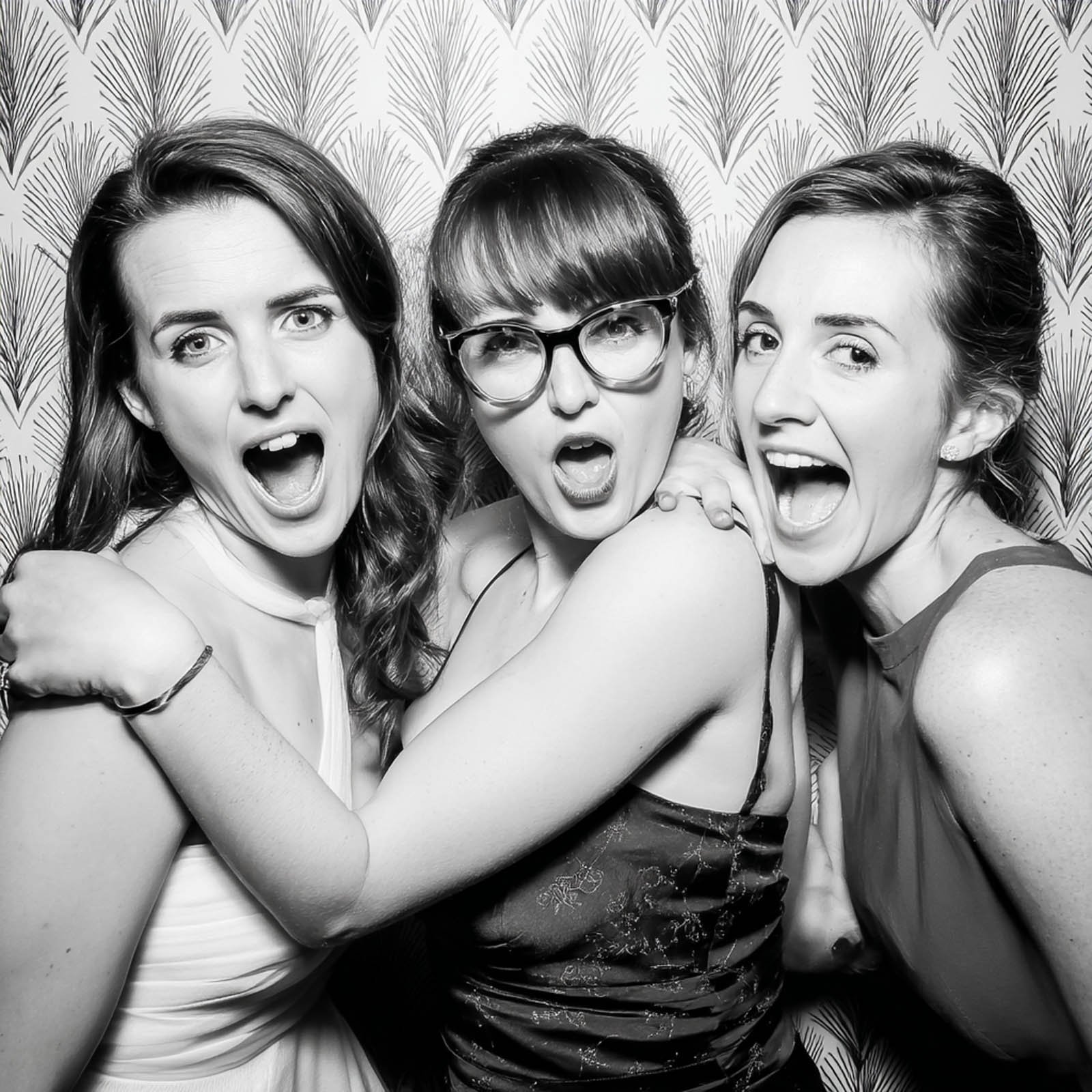 Black and white photo booth portrait of three women