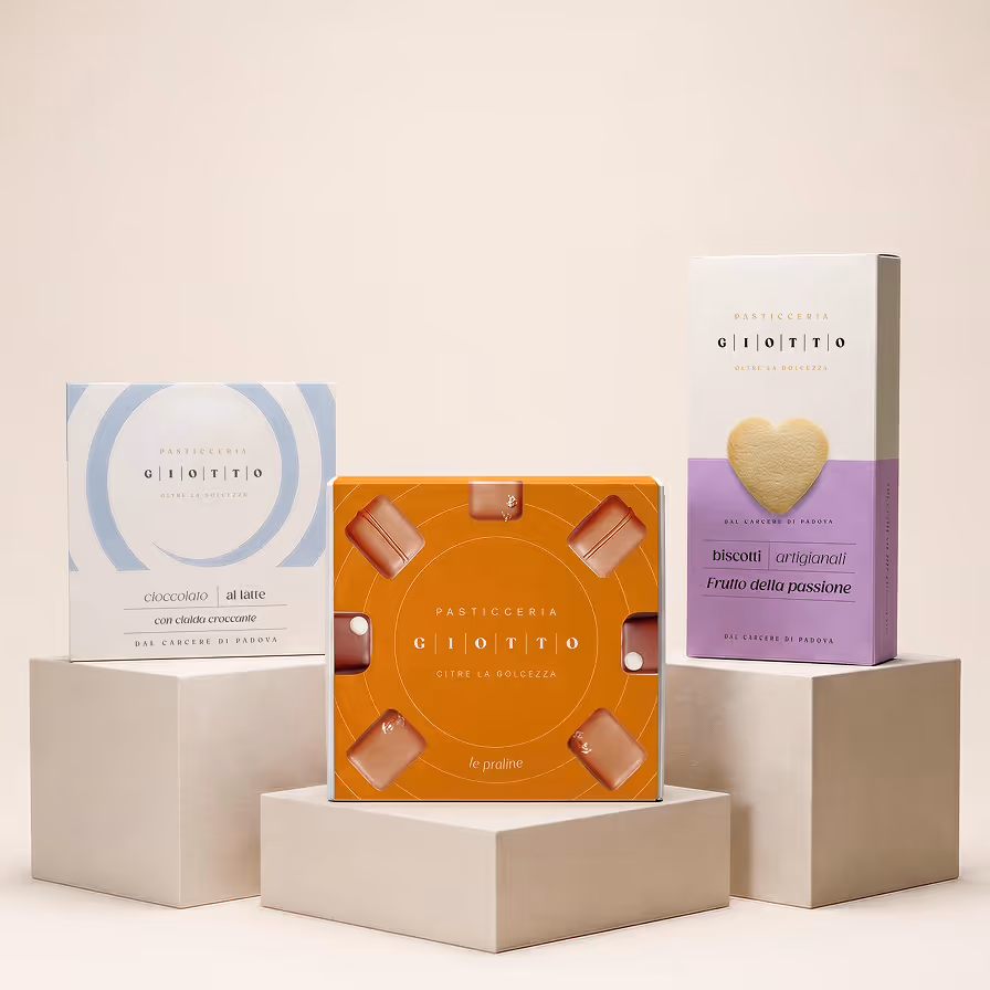 Tre confezioni eleganti di dolci Pasticceria Giotto con design minimalista in bianco, arancione e viola, esposte su piedistalli bianchi.