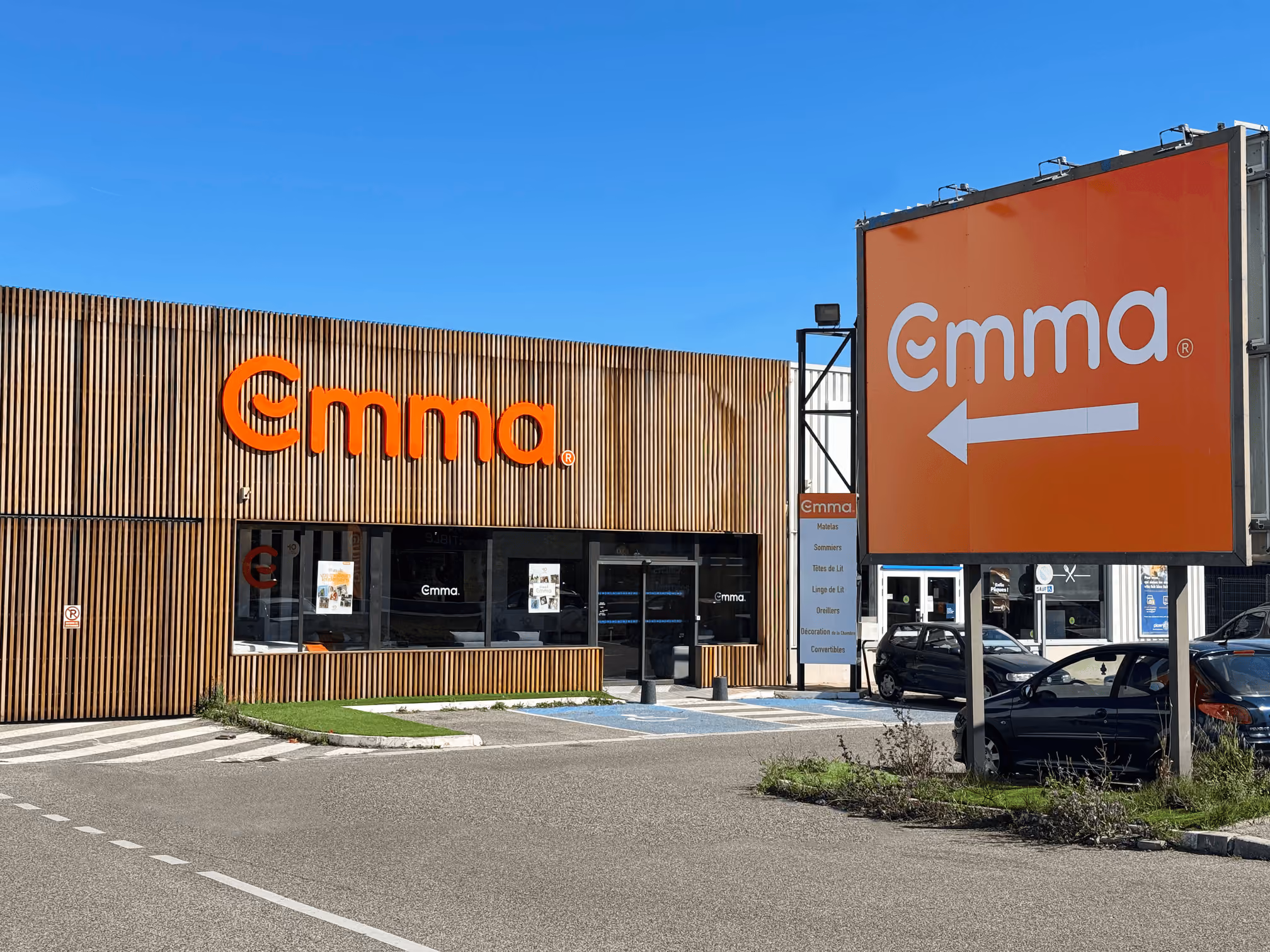 Façade d’un magasin Emma Plan de campagne avec un grand panneau orange et une flèche pointant à gauche.