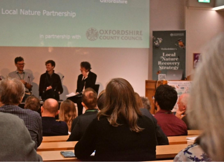 A group of people in front of a projector screenAI-generated content may be incorrect.