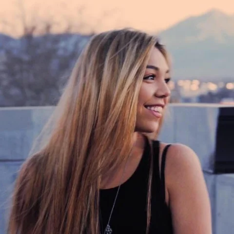 A woman with blonde hair and a black tank top.