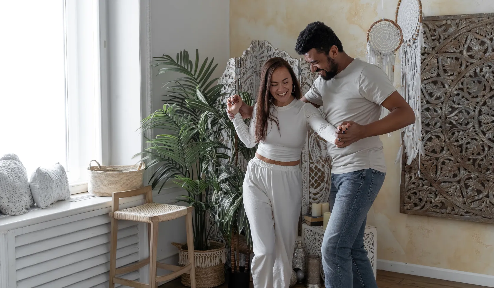 Happy couple dancing together in a stylish living space, depicting joyful home life at Liberty at Estrella Falls apartments in Goodyear, AZ.