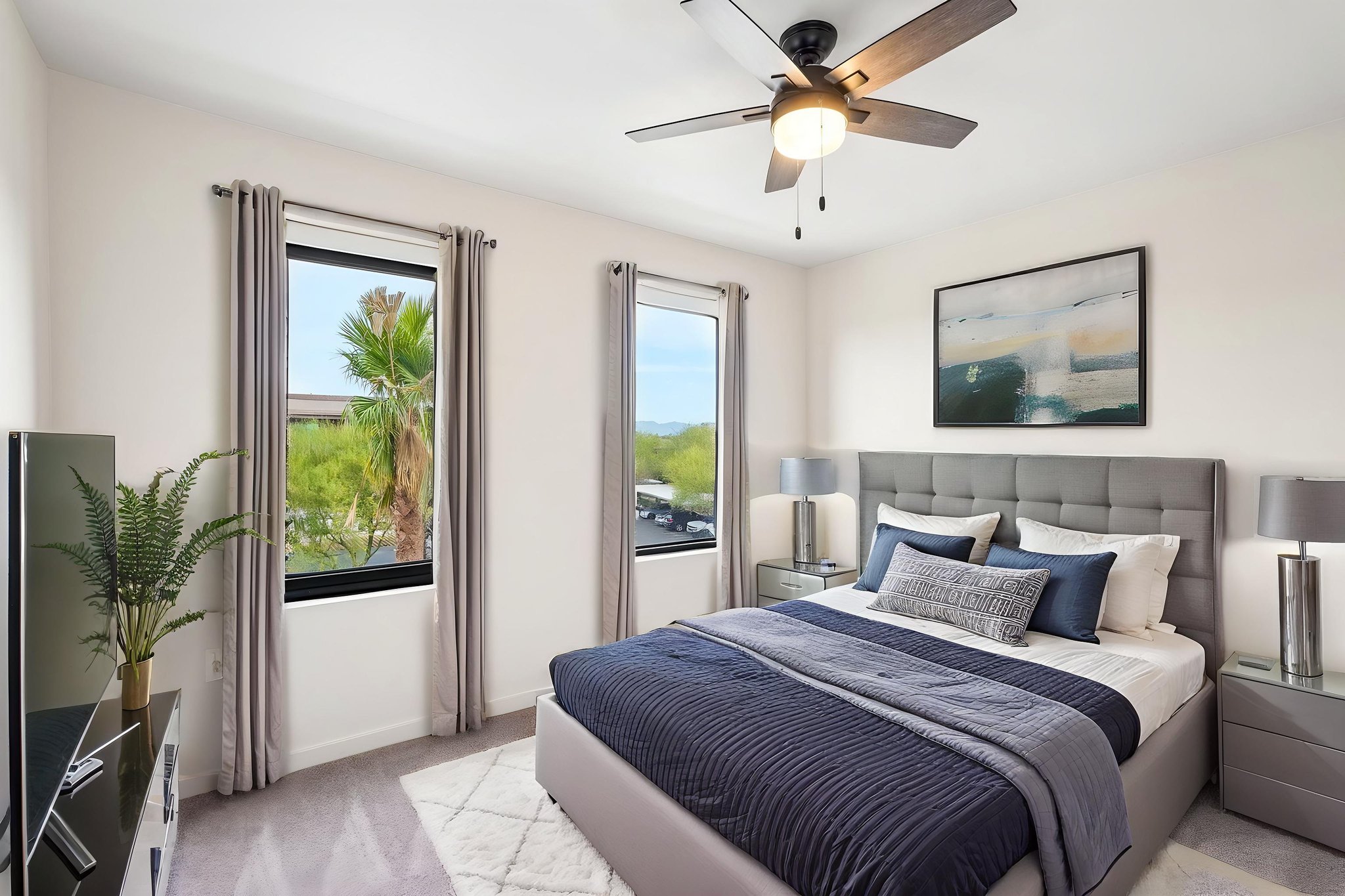 Bedroom with a bed, two nightstands, and a built-in closet with modern white doors at Liberty at Estrella Falls in Goodyear, AZ.
