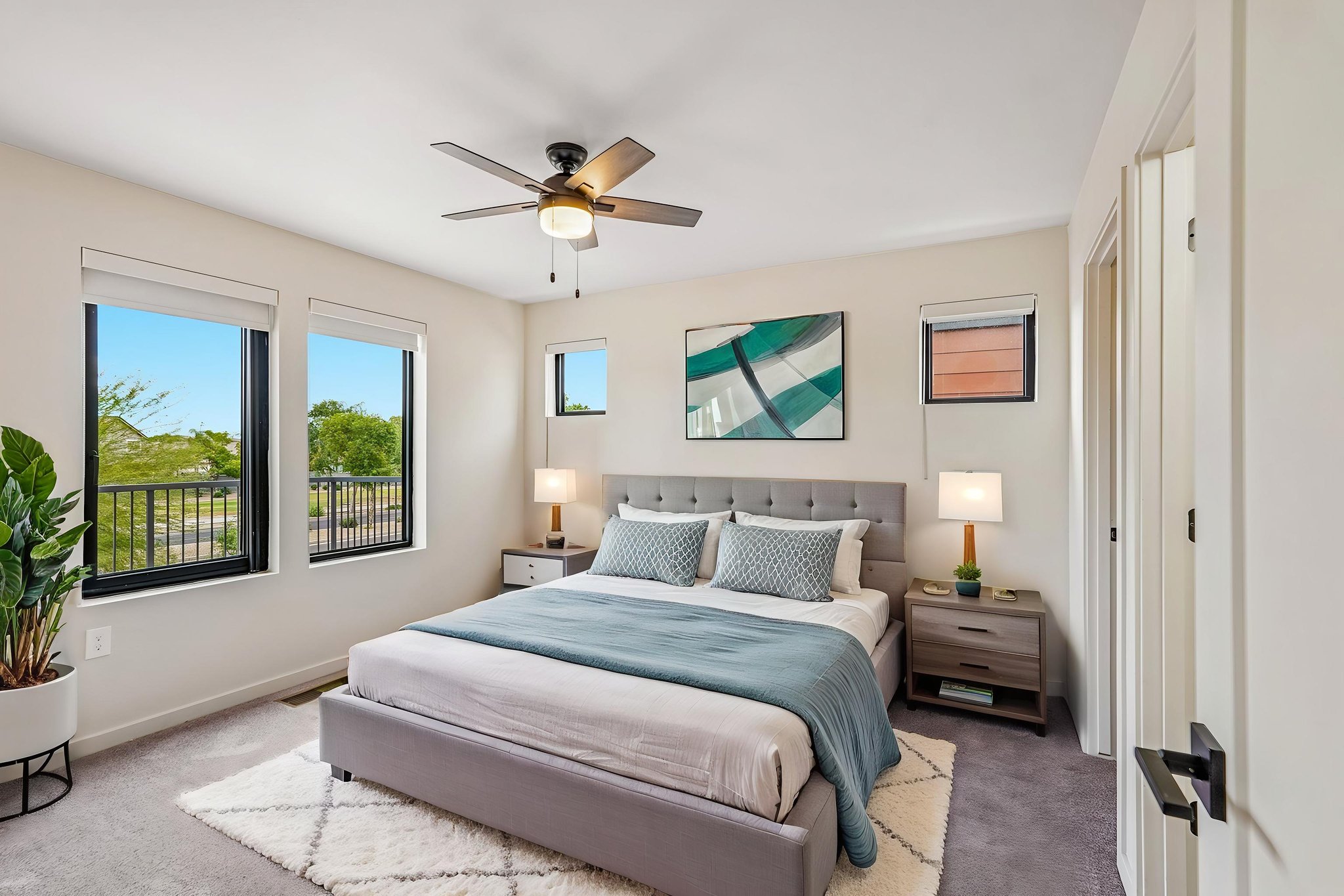 Spacious bedroom with a modern bed frame, two nightstands, and a large closet, in an apartment at Liberty at Estrella Falls in Goodyear, AZ.