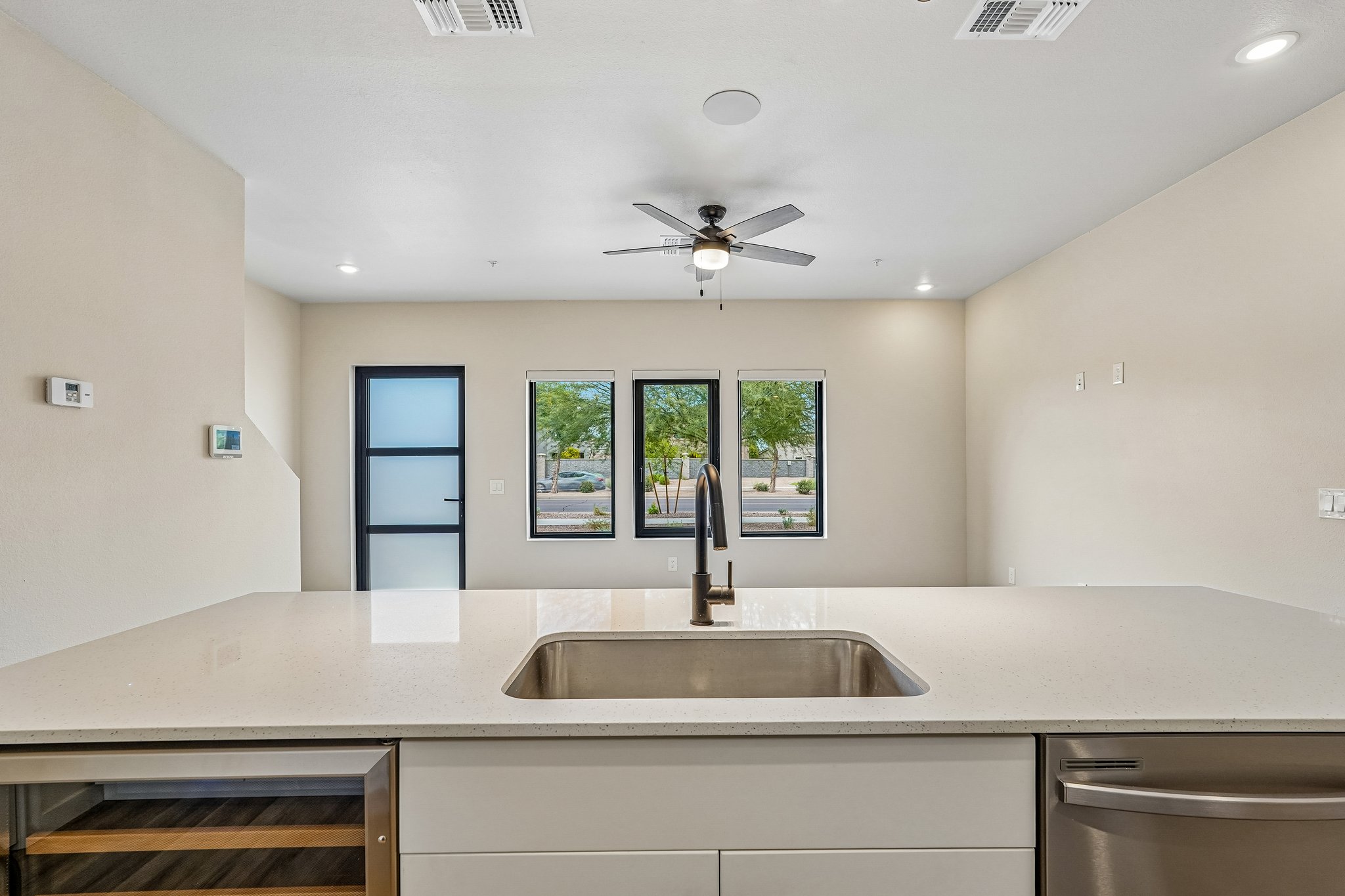 Contemporary kitchen with a large white island, bar seating, and stainless steel appliances at Liberty at Estrella Falls in Goodyear, AZ.