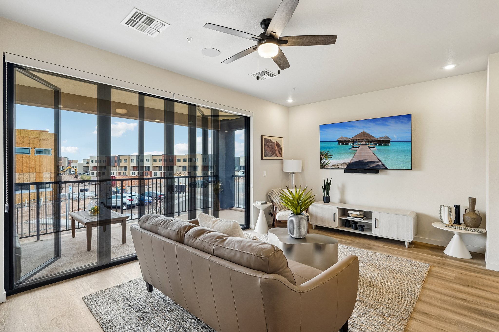 Bright apartment dining area with a wooden table, four chairs, and a large window, at Liberty at Estrella Falls in Goodyear, AZ.