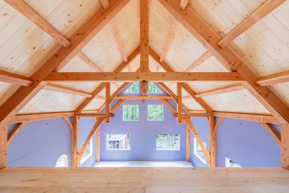 Wooden timber frame interior with exposed beams and large windows