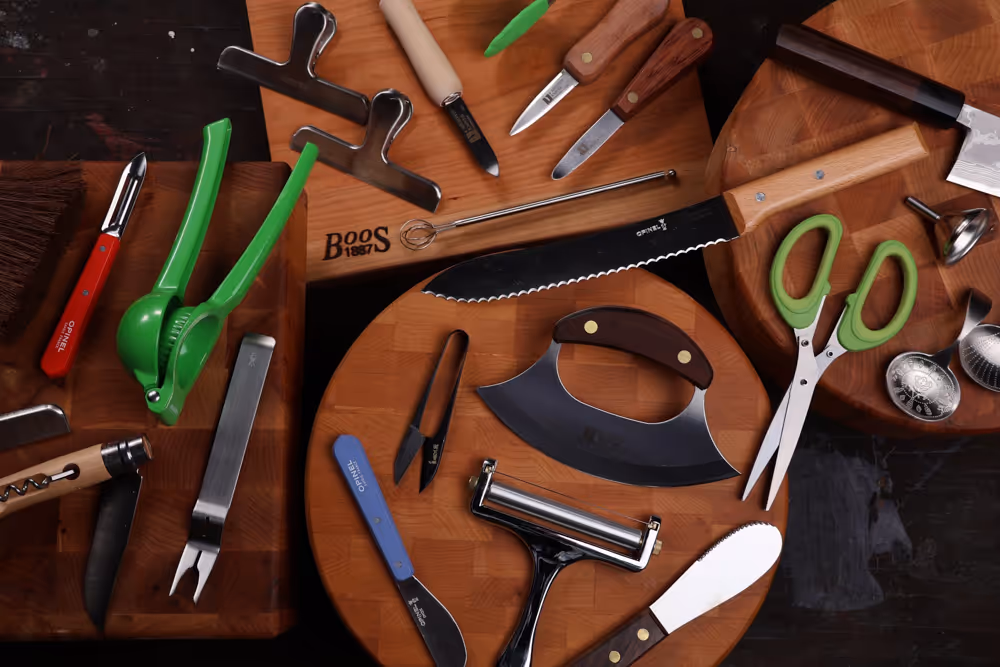 Kitchen utensils and tools scattered on wooden cutting boards