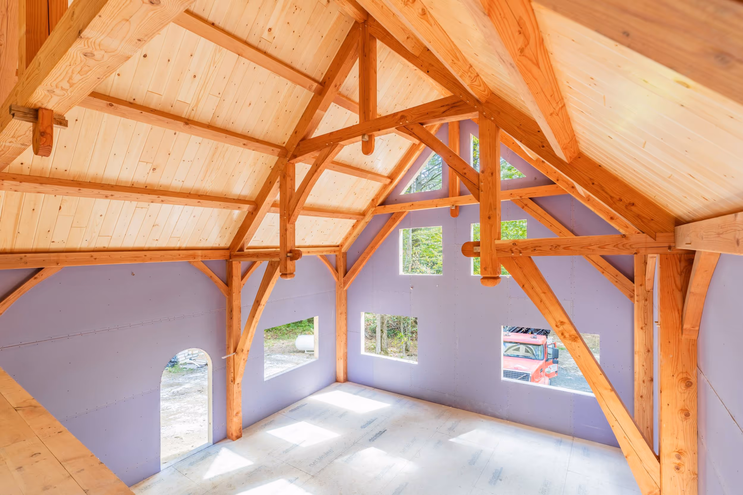 Wooden timber frame interior with lavender walls and multiple windows