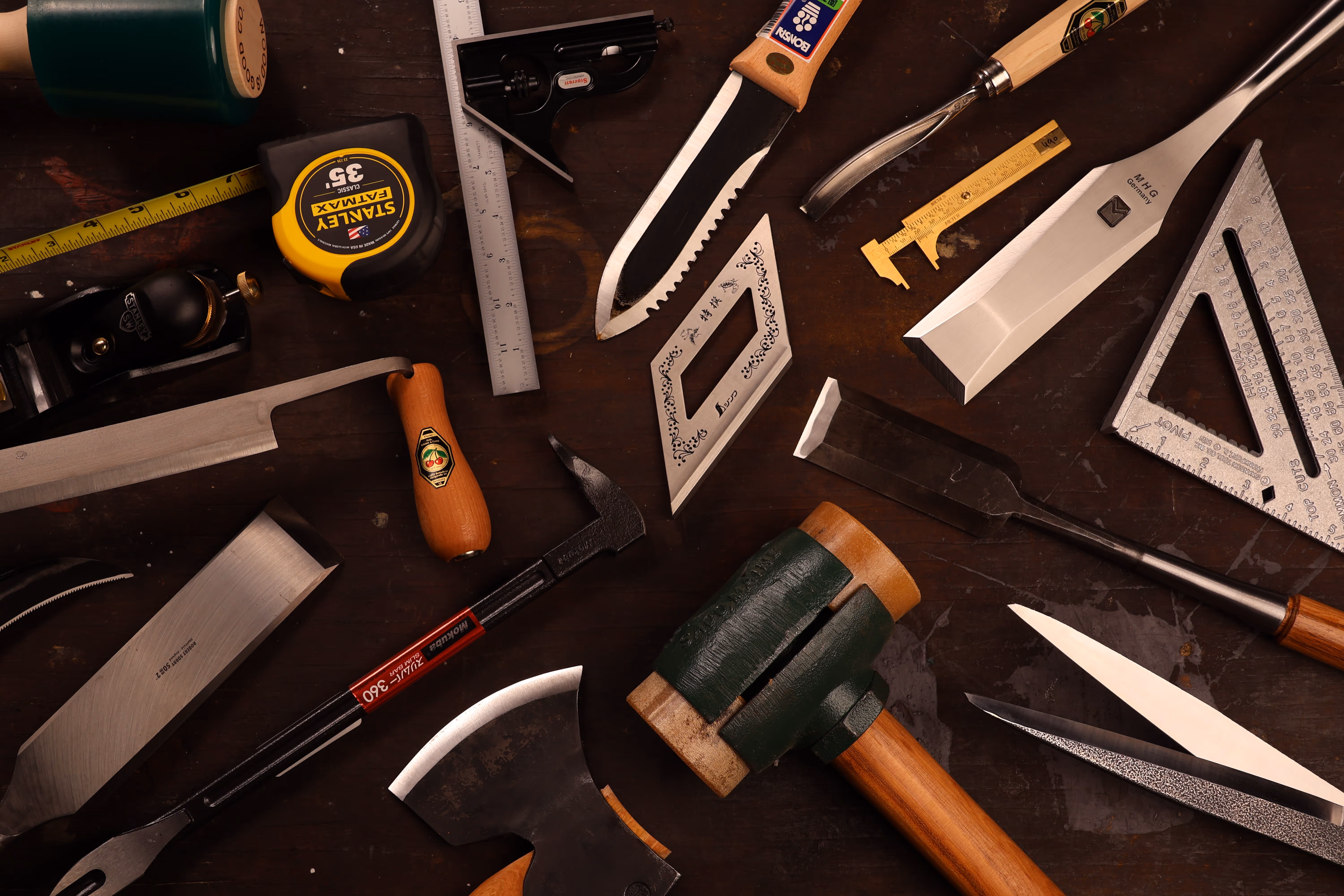Assorted woodworking and measuring tools scattered on a dark background