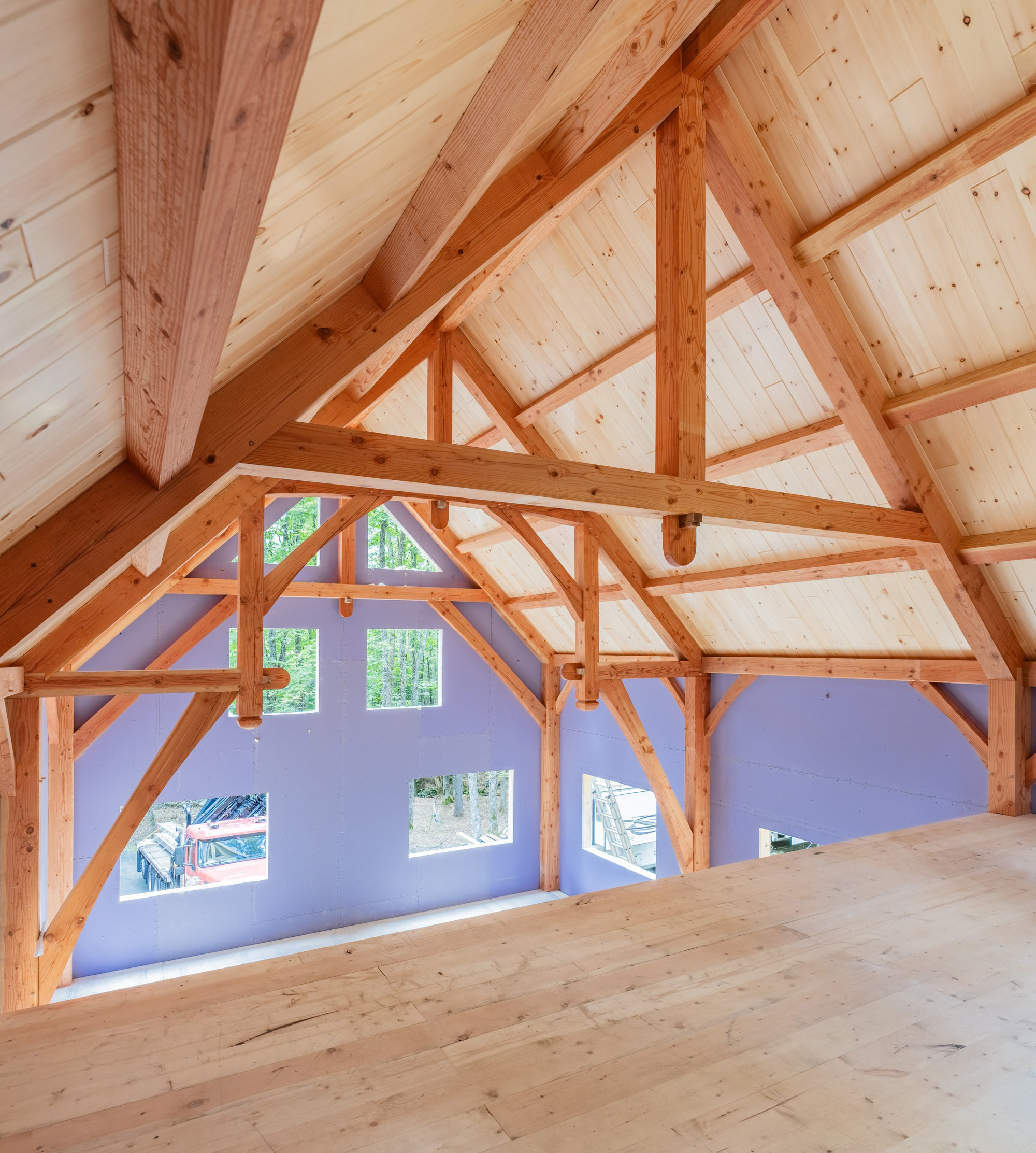Wooden timber frame interior with exposed beams and large windows