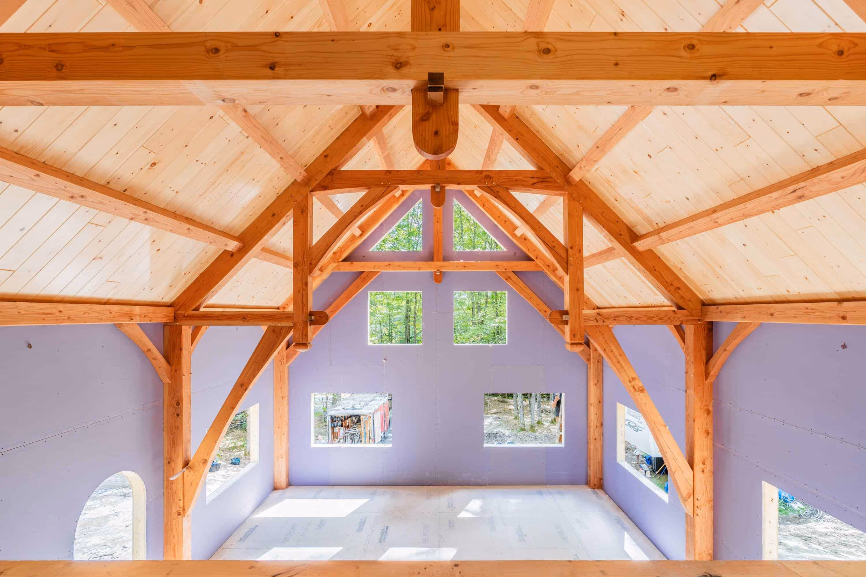 Wooden timber frame interior with lavender walls and forest view windows