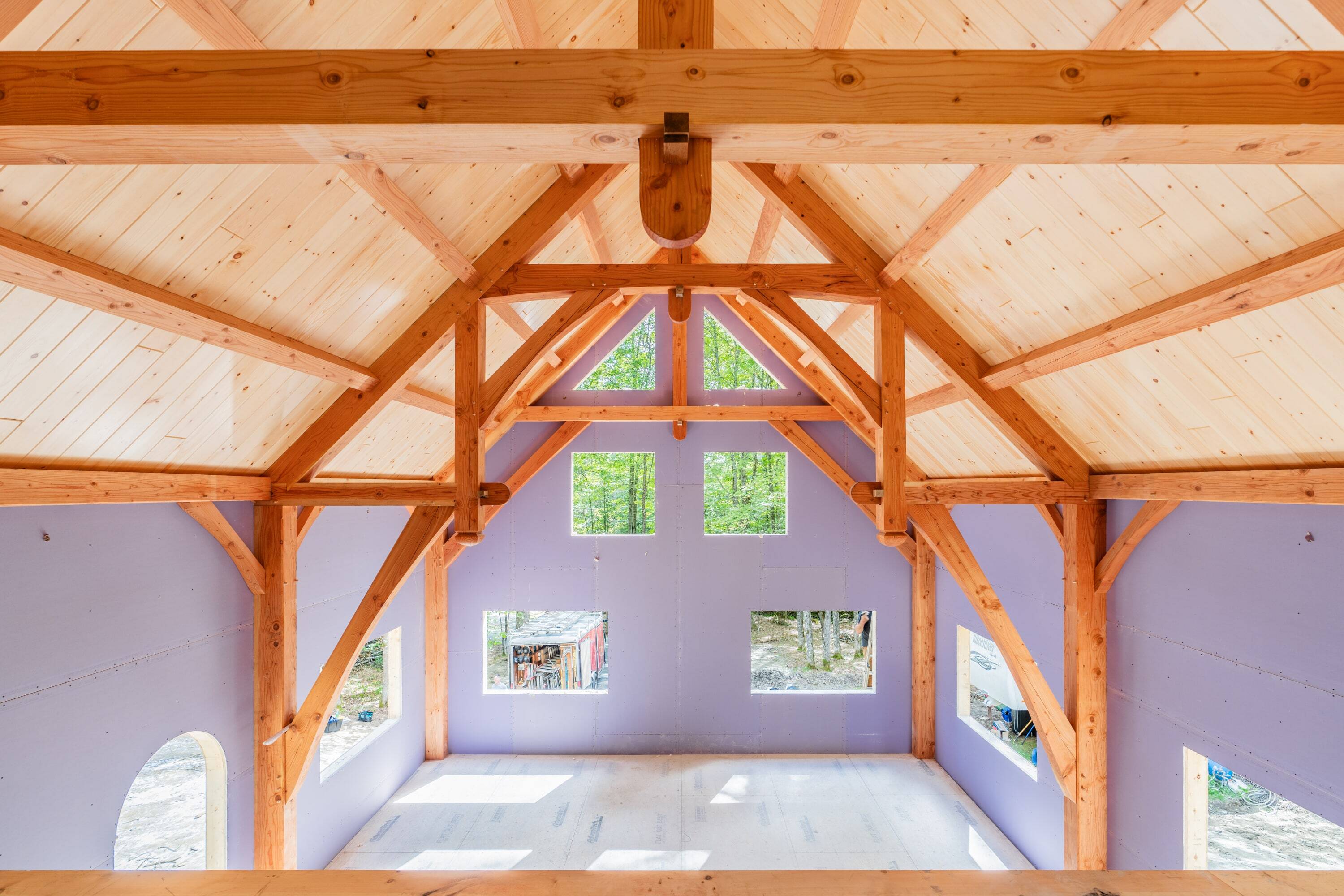 Wooden timber frame interior with lavender walls and forest view windows