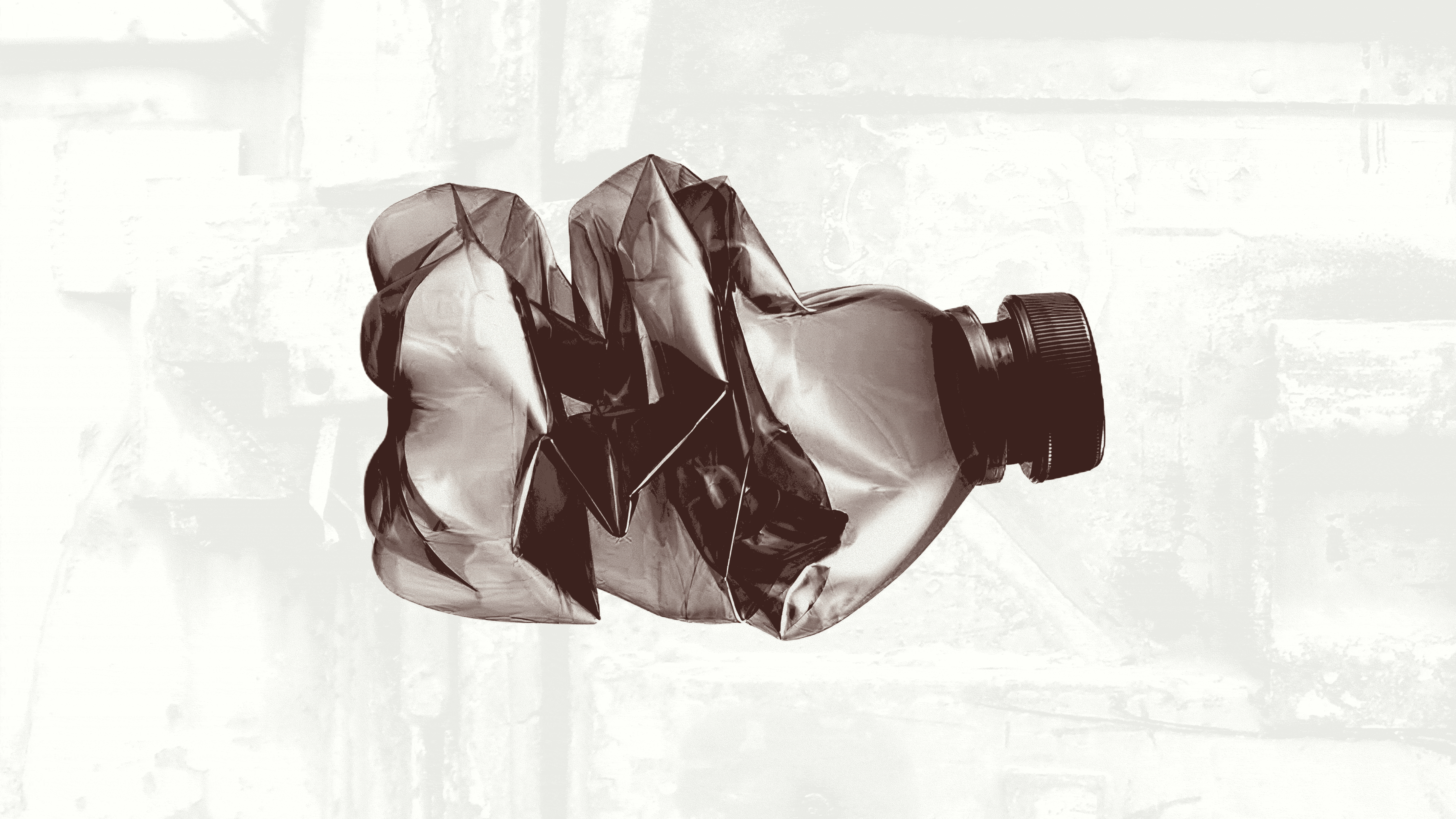 Crushed plastic bottle with a black cap against a light, textured background.