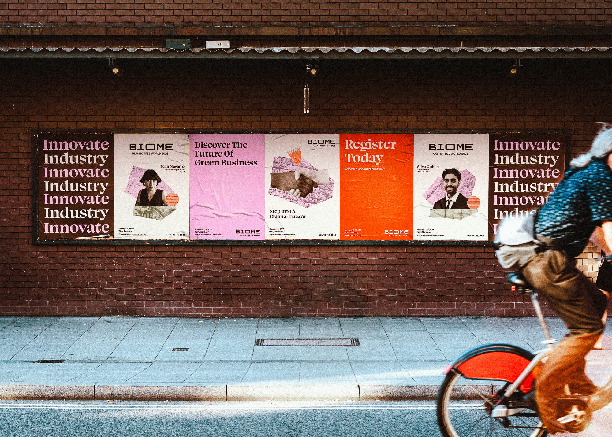 Outdoor brick wall with a row of posters promoting the Biome Plastic Free World 2025 conference, featuring speakers and registration information.