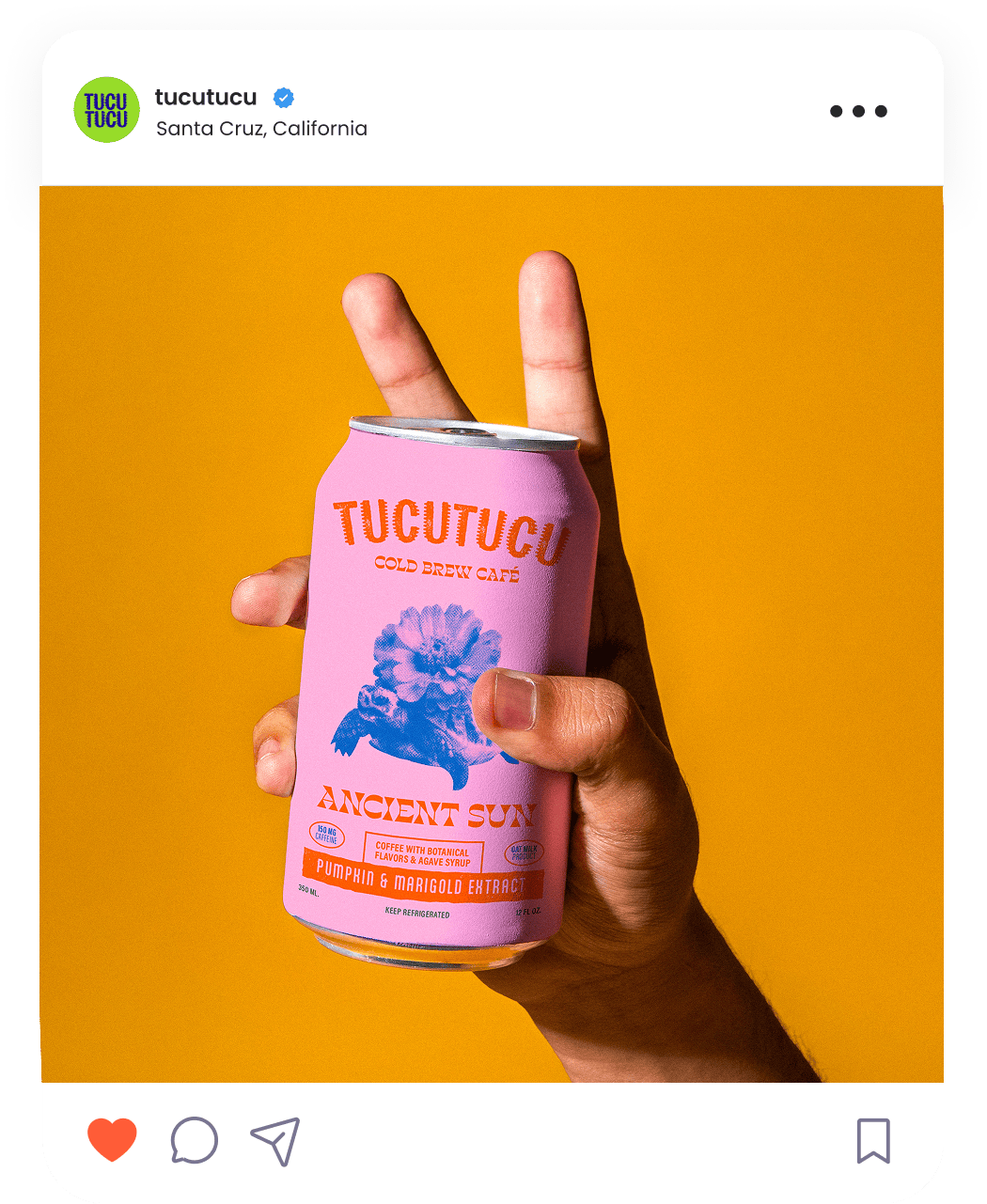 Hand holding a pink can of Tucutucu Ancient Sun cold brew coffee with pumpkin and marigold extract.