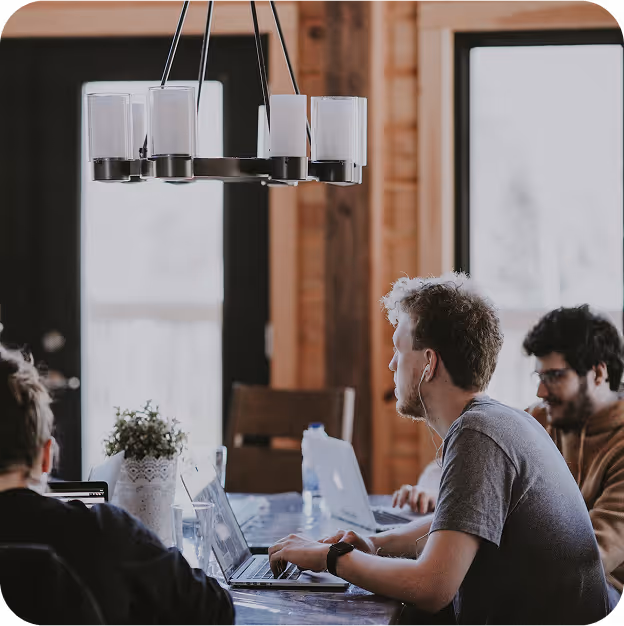 dev teams around a work table solving I.T. problems for their clients.