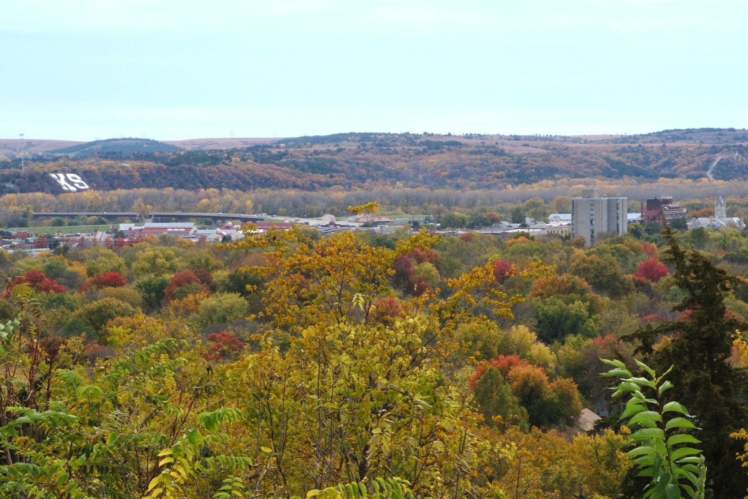 Fall foliage and downtown Manhattan, Kansas with the Flint Hills beyond