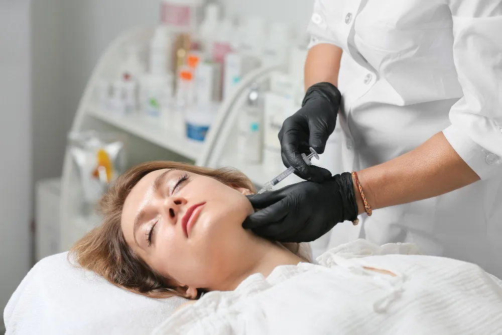 Woman receiving a cosmetic injection in her chin jaw filler treatment