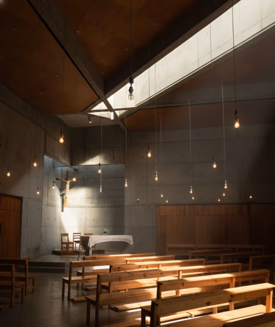Detail of church interior showing curated artwork, candles, and seating.