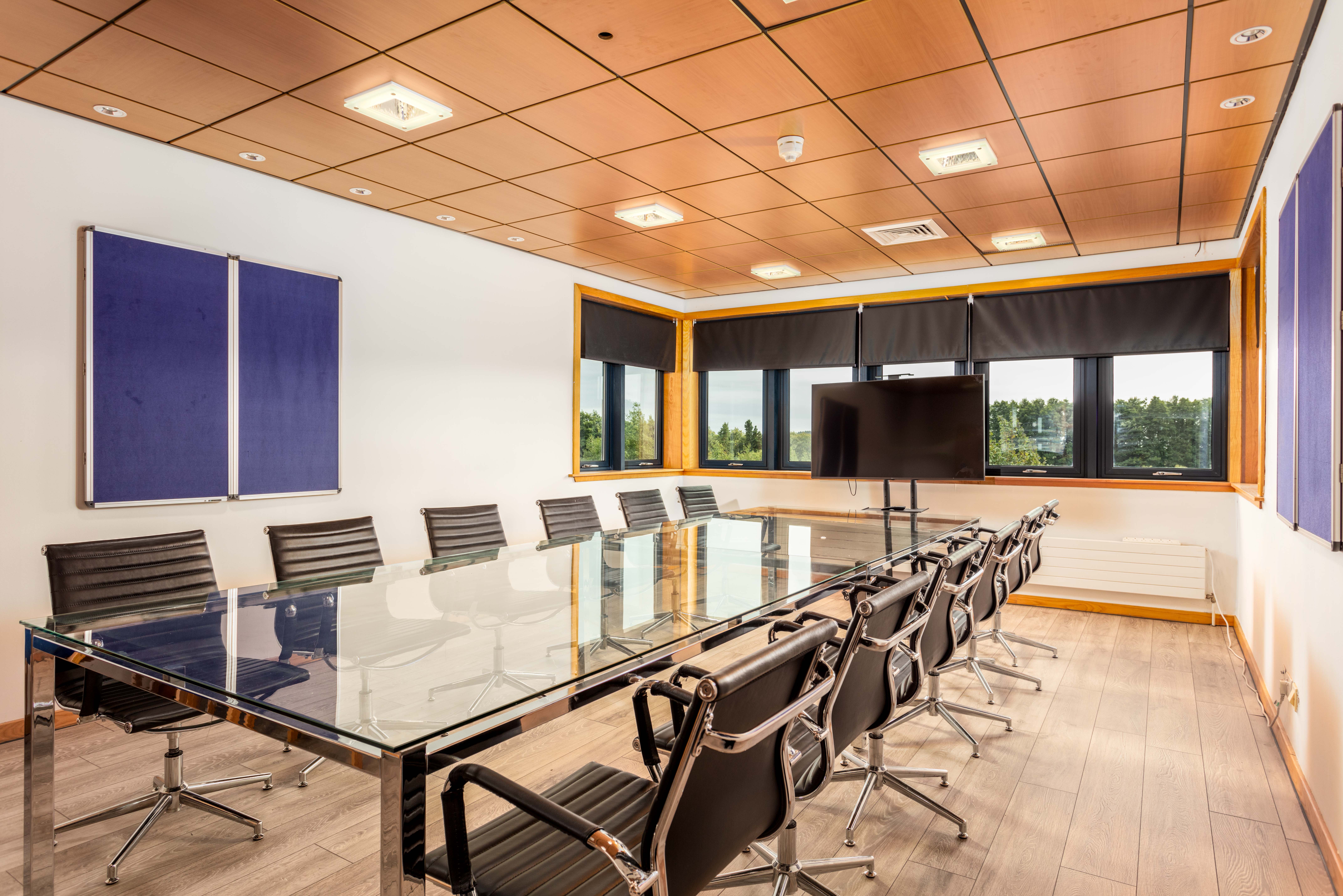 Professional meeting room equipped with a long conference table and minimalist design elements at Corespace Kilwinning