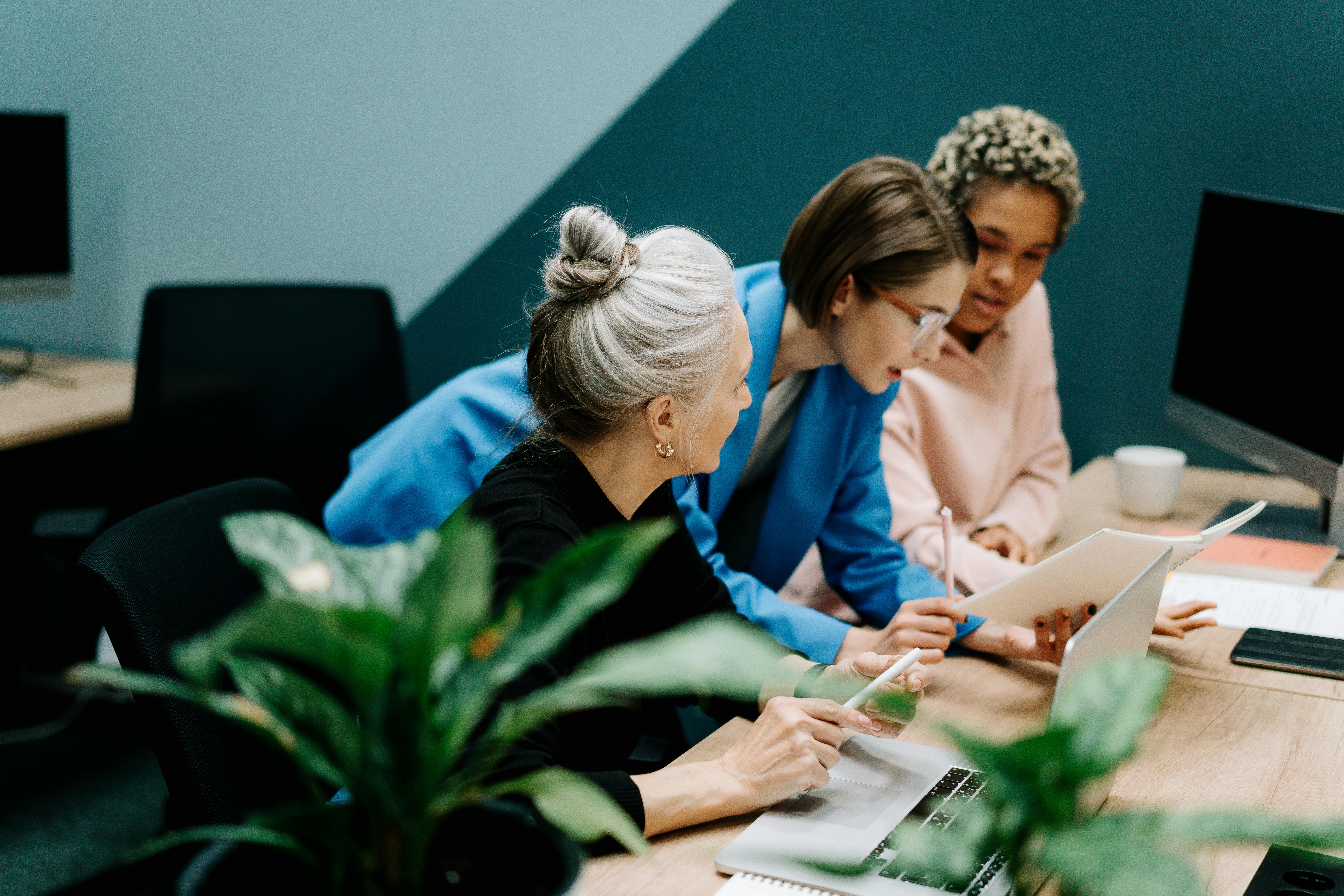 Team members engaging in a discussion around a desk in a collaborative workspace.