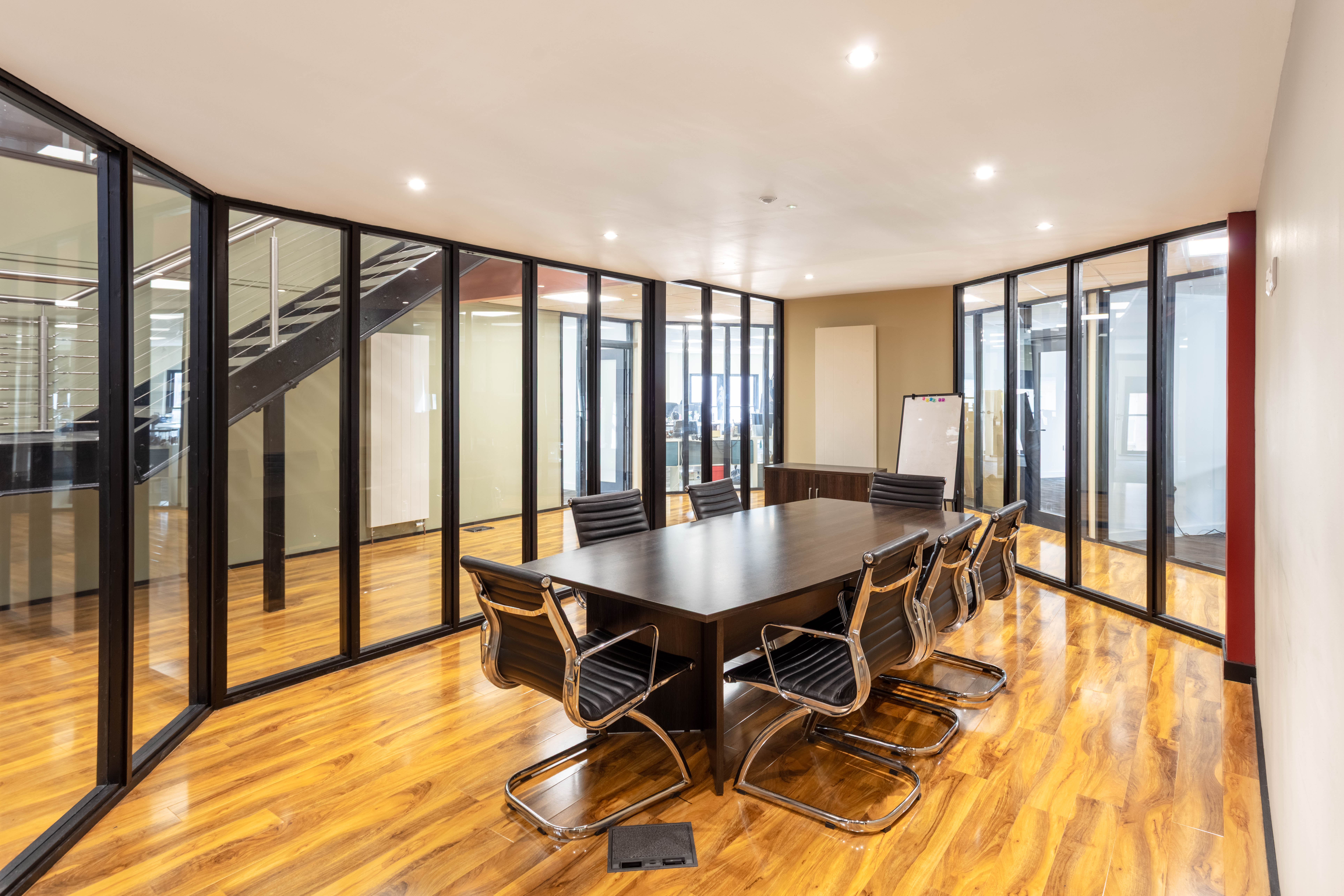 A bright, board room meeting space at Corespace Kilmarnock showing modern furniture, a large glass desk and full size interior windows